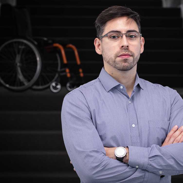 Enlarged view: Portrait of Diego Paez-Granados with wheelchair in background